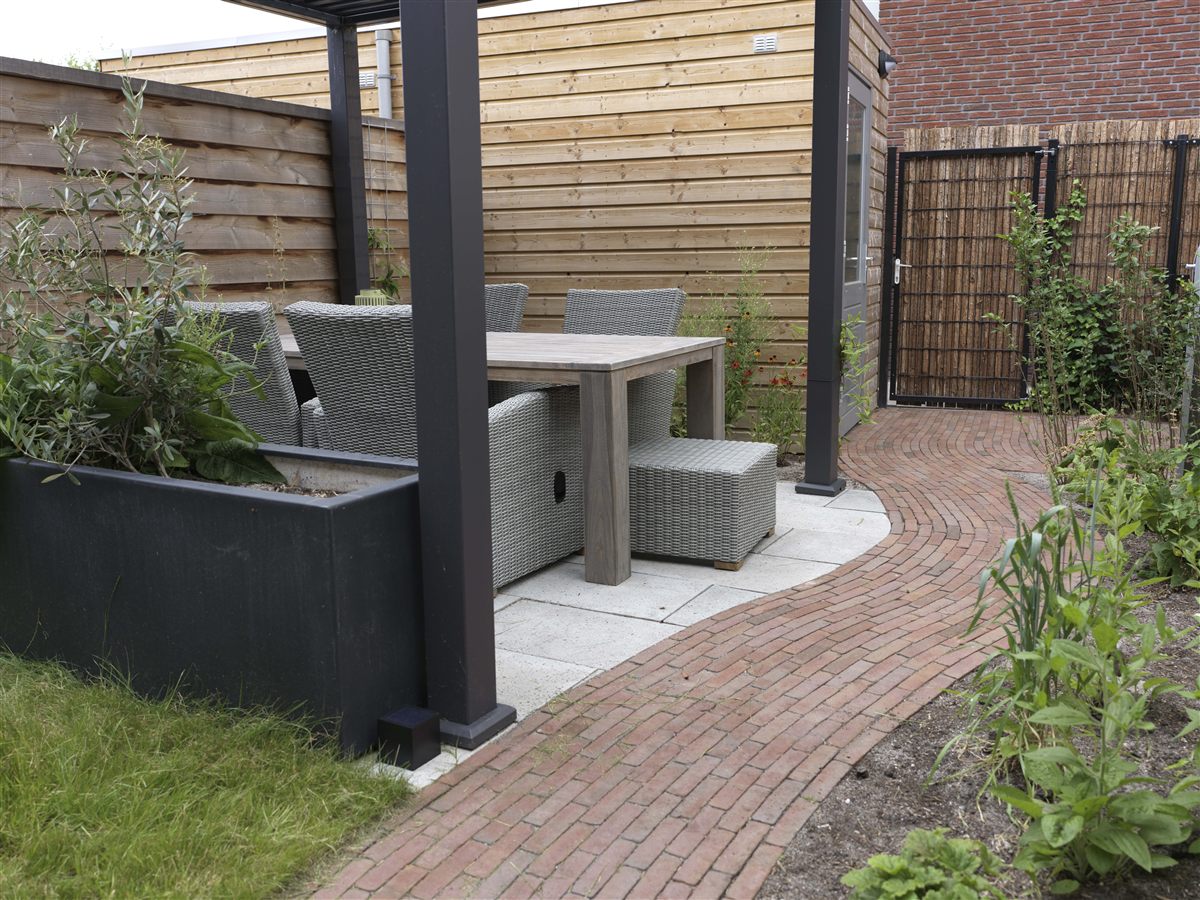 Een overkapt terras met tuinmeubilair
